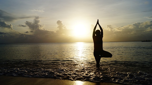 Benefits of Exercise on Parkinson's Disease - Photo of person balancing durign Yoga on the Beach