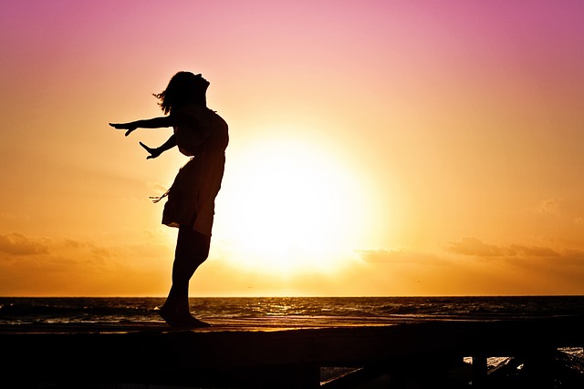 Benefits of Exercise on Parkinson's Disease - photo of woman on beach enjoying the sunrise
