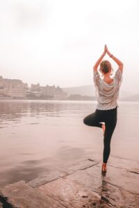 Flexibility with Parkinson's - Photo of a woman doing a Yoga Stretch on a pier.